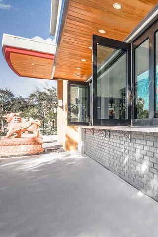 Exterior of retail building with Marvin Signature Coastline Bi-fold Door and Storefront Picture Window