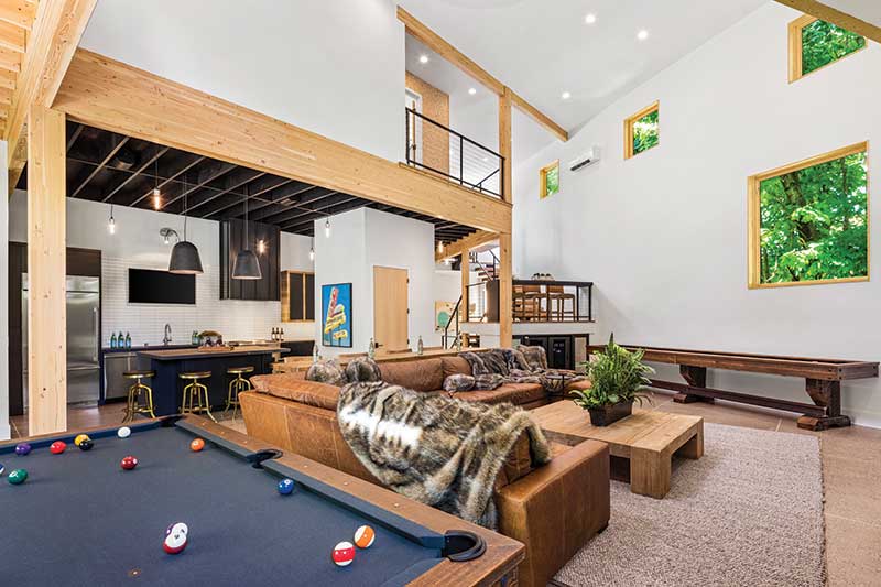 Entertainment space in a modern-industrial home featuring Marvin Ultimate Picture windows and Marvin Ultimate Awning windows.
